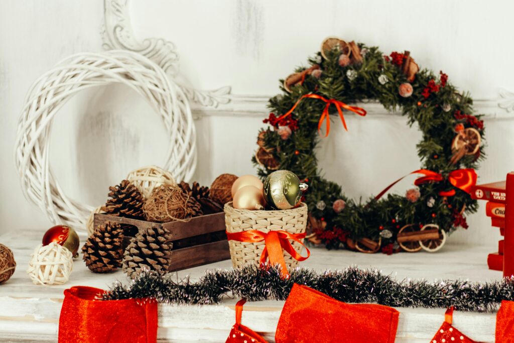 Holiday wreath, red ribbons, and festive pinecones on a table